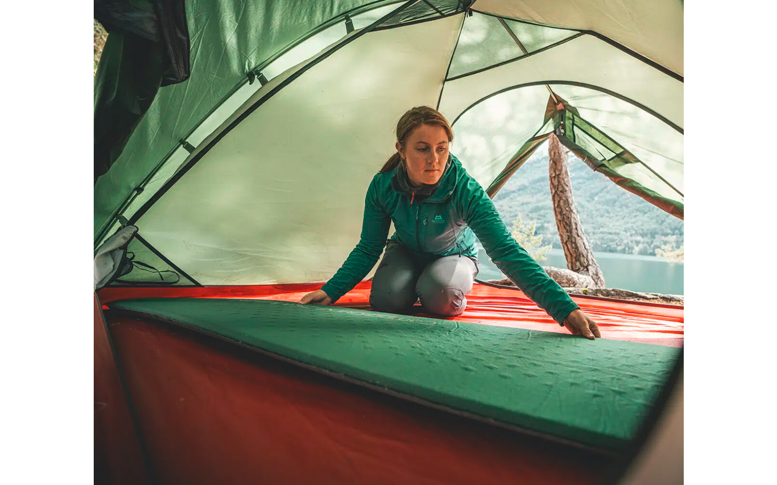 Persoon zit binnenin een tent en kijkt naar buiten