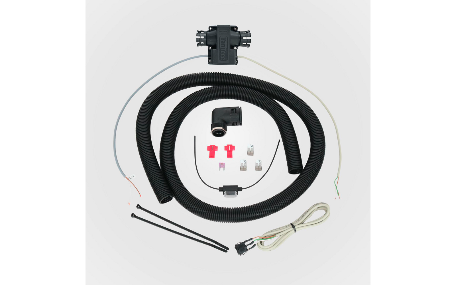 Boîtier en plastique noir, deux gaines ondulées noires enroulées, connecteur coudé noir, câble blanc avec prise, plusieurs fils fins, trois raccords rouges, deux fusibles à lame transparents, trois colliers de serrage noirs, petit élément noir