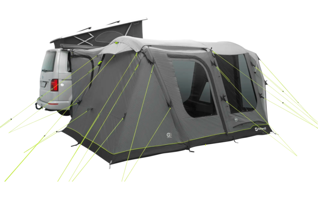 Wohnmobil mit angebautem grauem Vorzelt auf Grasfläche bei bewölktem Himmel