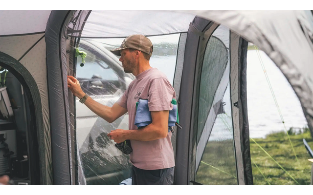 Frau steht neben einem Auto und öffnet die Fahrertür