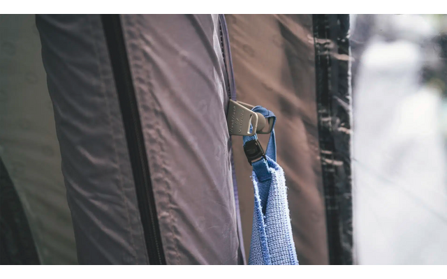 Vogel sitzt auf einem Stoffzelt vor unscharfem Hintergrund