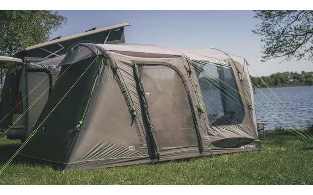 Grünes Zelt steht auf einer Wiese neben einem See