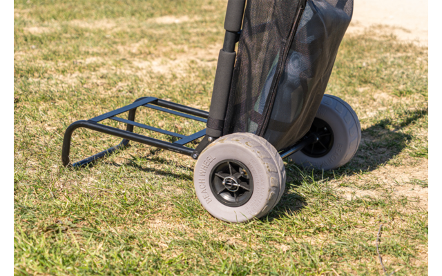 Carro negro de dos ruedas con ruedas grises y bolsa negra sobre césped
