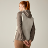 Rear view of a woman with a red ponytail wearing a hooded jacket with a light quilted back, hands clasped behind her back