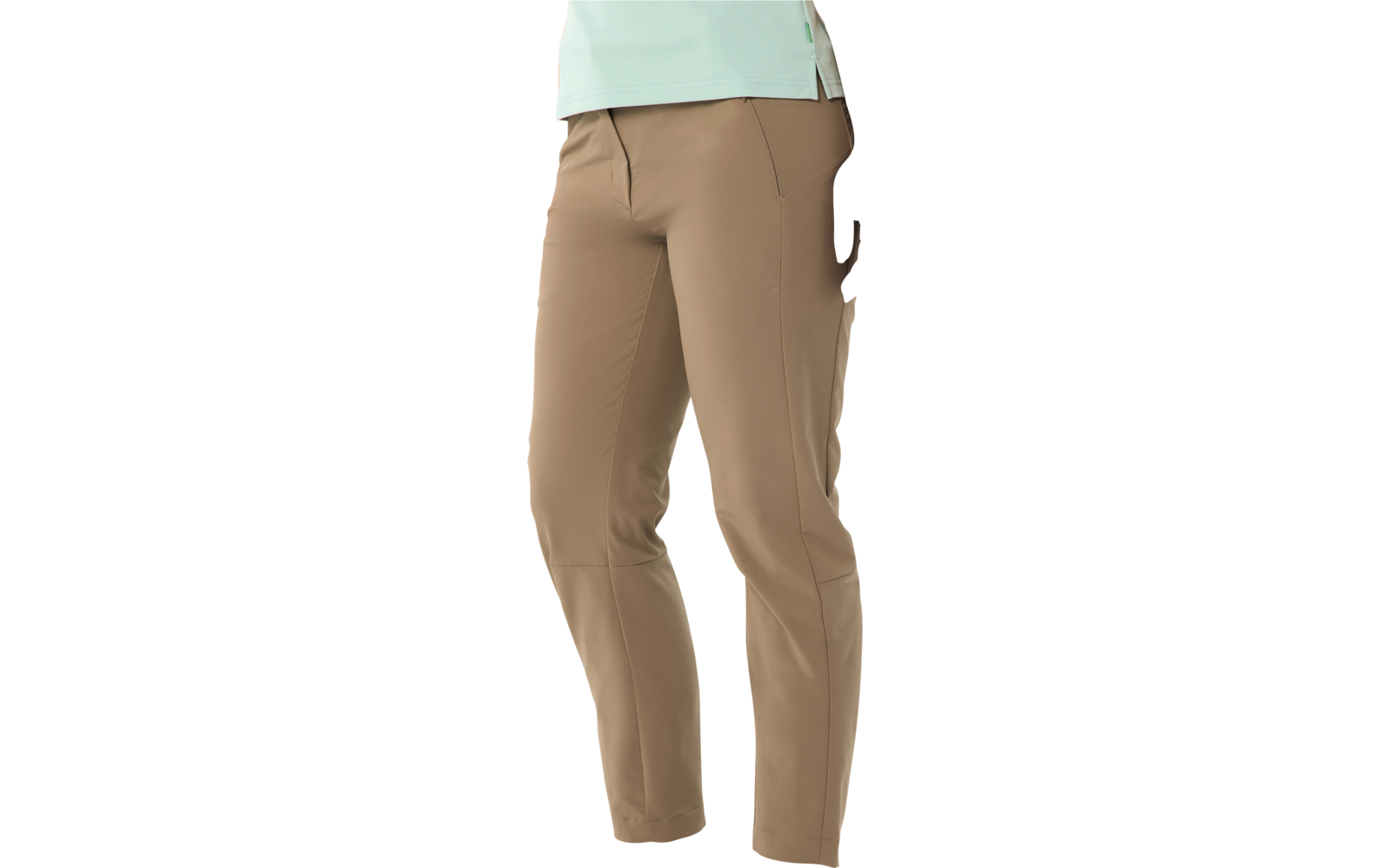 Onderlichaam van een persoon in taupekleurige, enkellange broek met zichtbare zijzakken, witte sneakers en een lichtgroen bovenstuk, tegen een witte achtergrond