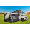 Wohnmobil mit angebautem grauem Vorzelt auf einer grünen Wiese bei sonnigem Wetter