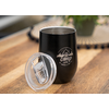 Black insulated cup with removable transparent lid, placed on wooden surface