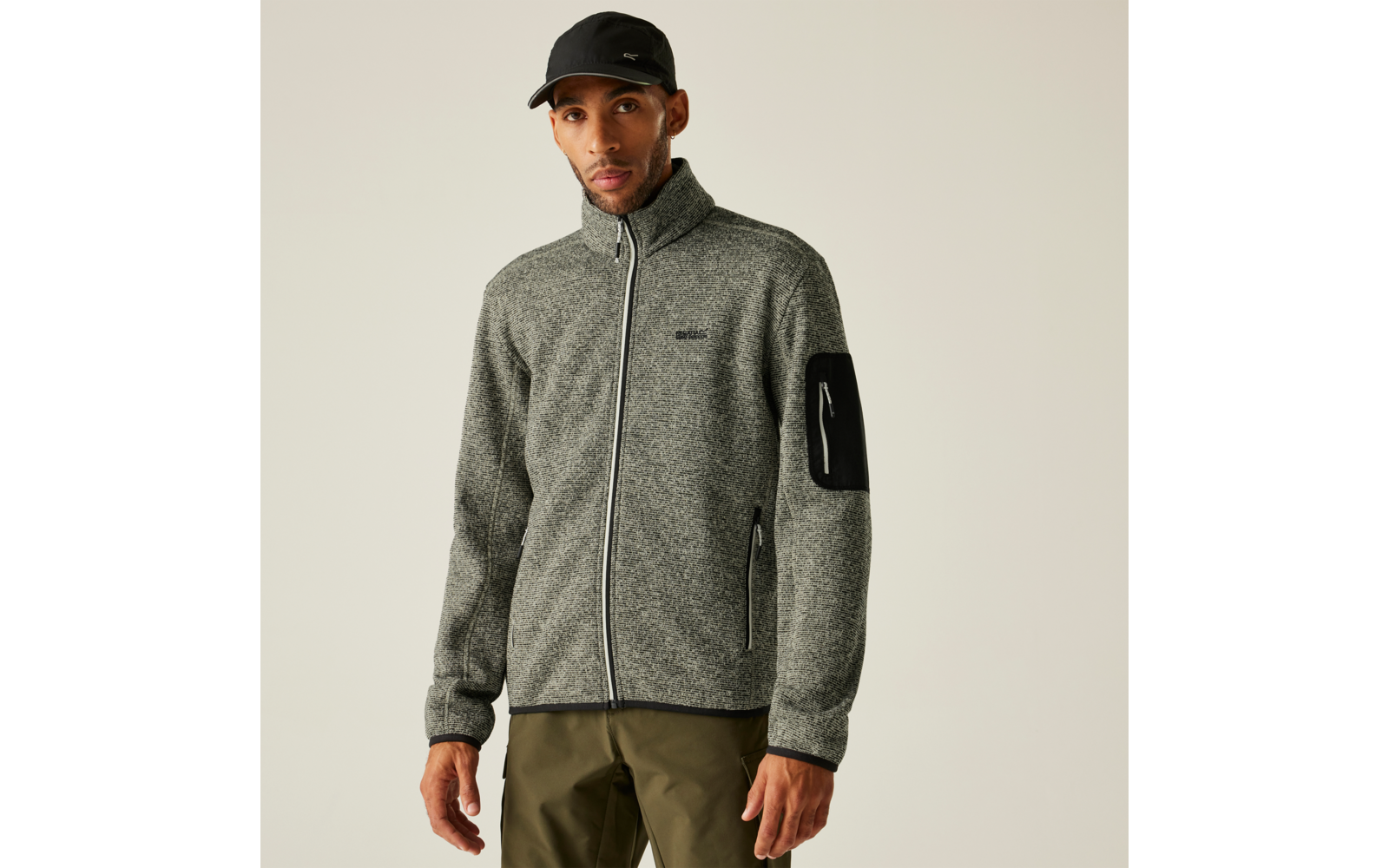 Mann trägt graue Fleecejacke und schwarzen Baseballcap