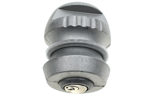 Graues, zylindrisches Metallobjekt mit erhabenen Rillen oben, einer spiralförmigen Feder um die Mitte und sichtbarem Schrauben- oder Bolzenkopf unten, vor weißem Hintergrund