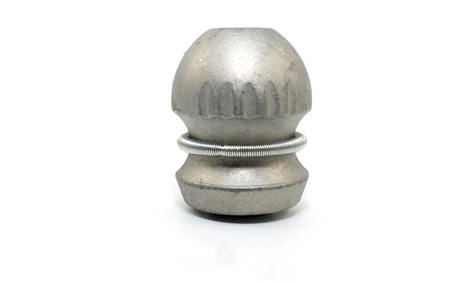 Silberfarbenes, abgerundetes Metallobjekt mit Rillen oben und unten und einem gewickelten Metallring um die Mitte, vor weißem Hintergrund