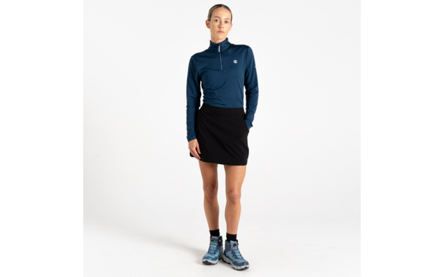 Vrouw staand, donkerblauw shirt met lange mouwen en korte rits, zwarte korte rok, enkelsokken en blauwe wandelschoenen, witte achtergrond