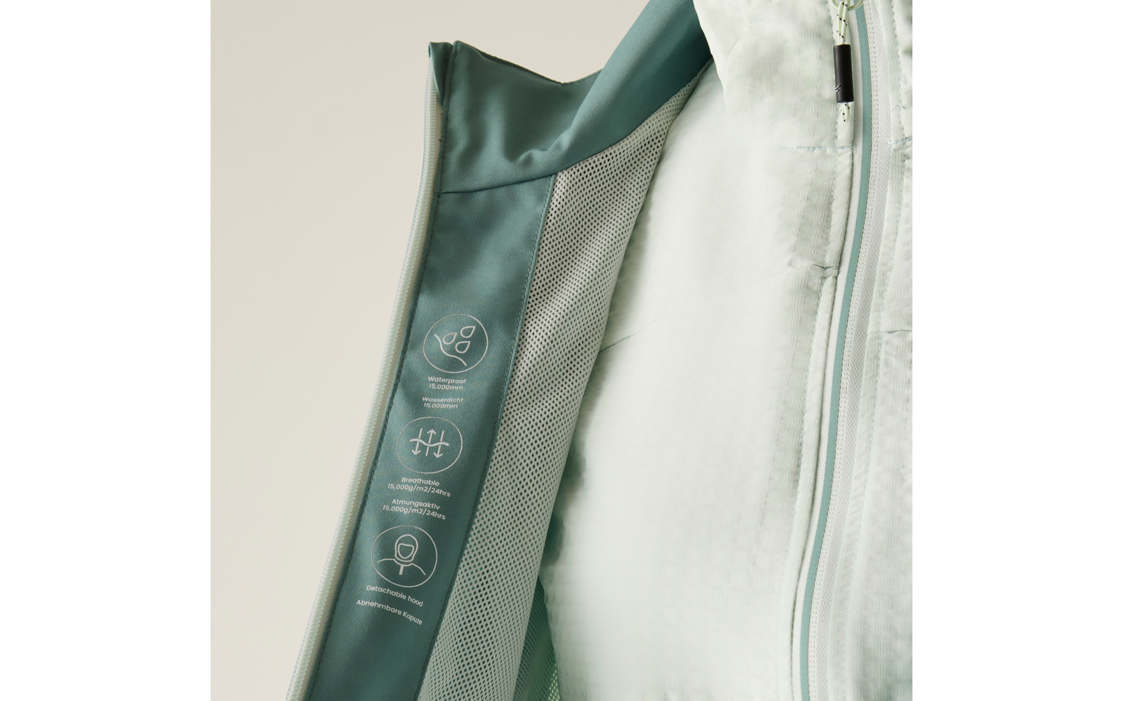 Geöffnete Jacke mit hellgrüner Innenfütterung, Netzstoffeinsatz und drei weißen Piktogrammen am inneren Reißverschluss-Steg