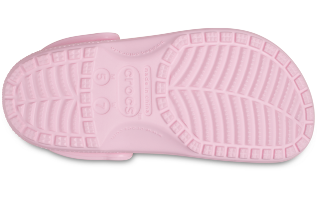 Unterseite eines einzelnen hellrosa Clogs mit profilierter Sohle, Fersenriemen und geprägtem Schriftzug 'crocs'