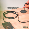 Schwarzes Ladekabel mit Stecker, das auf einem hellen Holztisch liegt, daneben zwei schwarze runde Gegenstände