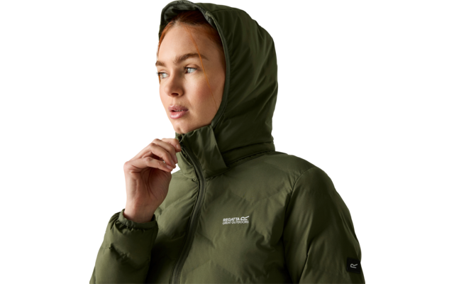Persona con capelli castani che indossa una giacca imbottita con cappuccio verde oliva, cappuccio alzato, mano sulla cerniera, sguardo verso sinistra su sfondo chiaro uniforme