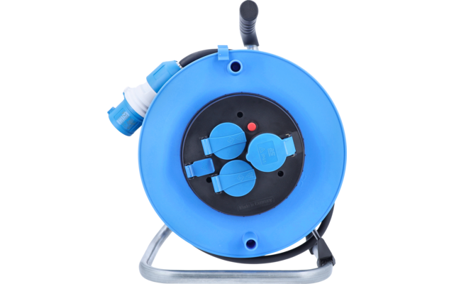 Runde blaue Kabeltrommel mit aufgewickeltem schwarzem Kabel, drei blauen abdeckbaren Steckdosen auf schwarzer Frontplatte, Metallständer und schwarzem Griff auf weißem Hintergrund