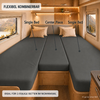 Interieur van een camper met een driedelig donkergrijs matrasoppervlak, drie beige kussens, houten panelen, warme inbouwverlichting, twee zijramen met berglandschap en zichtbare teksten 'Single Bed' en 'Center Piece' en banners