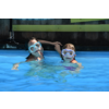 Zwei Personen mit Schnorchelmasken schwimmen in einem Pool und halten Händchen