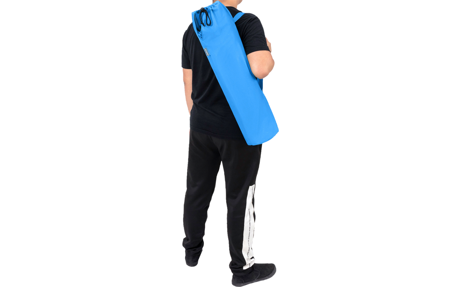 Person von hinten, trägt eine lange blaue zylindrische Tasche über der Schulter, schwarzes T‑Shirt und schwarze Hose mit weißem Streifen
