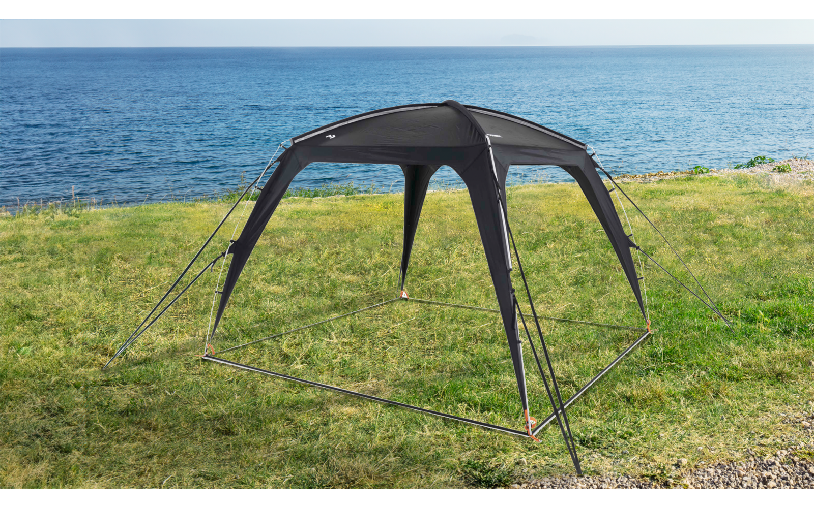 Offenes dunkelgraues Zeltgestell mit vier gebogenen Stützen, sichtbarem Gestänge, orangen Heringen und Abspannleinen auf weißem Hintergrund