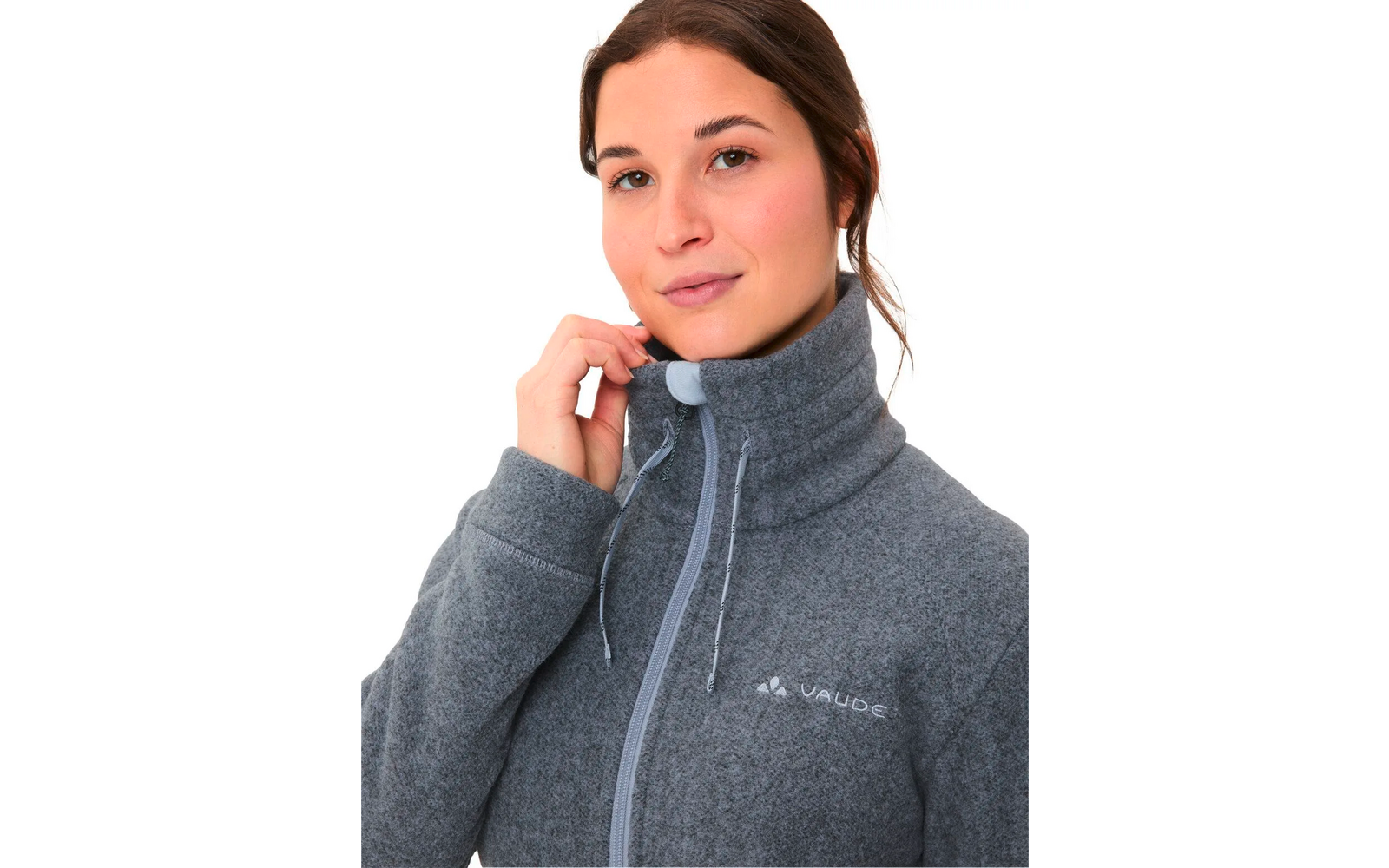 Junge Frau mit dunklen Haaren trägt einen grauen Outdoor-Pullover mit Reißverschluss