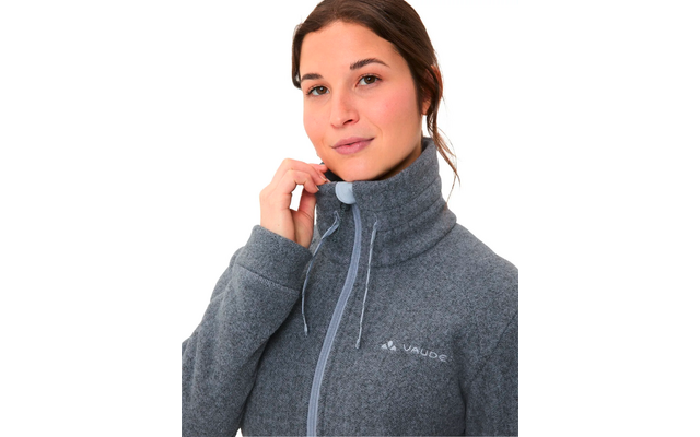 Junge Frau mit dunklen Haaren trägt einen grauen Outdoor-Pullover mit Reißverschluss