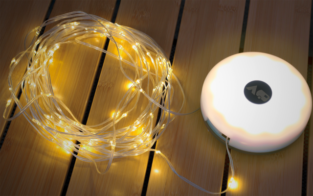 Lichterkette mit gelben LED-Lichtern und runder weißer Basis auf Holzboden