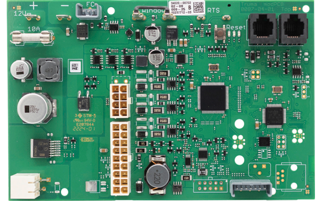 Grüne Leiterplatte mit verschiedenen elektronischen Bauteilen, Steckverbindern, Kondensatoren, integrierten Schaltkreisen und Widerständen
