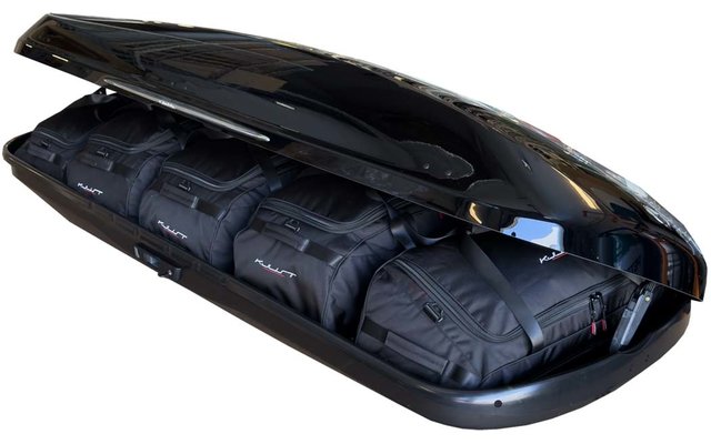 Glänzende schwarze, geöffnete Dachbox mit vier schwarzen Reisetaschen im Inneren