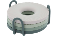 Vier runde, gerippte Scheiben in Weiß und Grüntönen mit mittigem Loch, gestapelt in einem dunkelgrünen Halter mit zwei seitlichen Bügeln