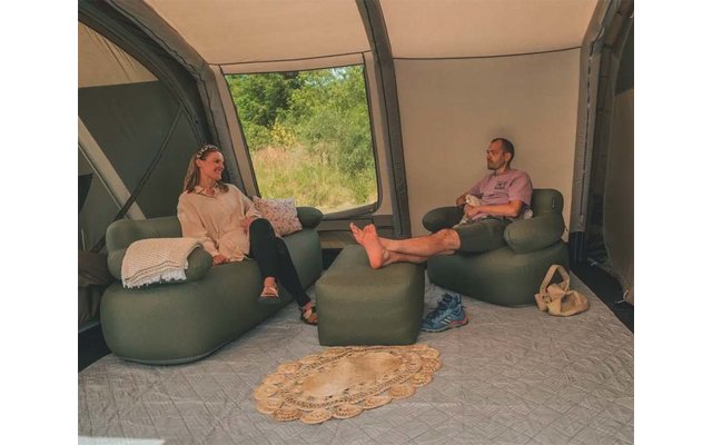 Zwei Personen sitzen auf Sitzsäcken in einem Raum mit großem Fenster