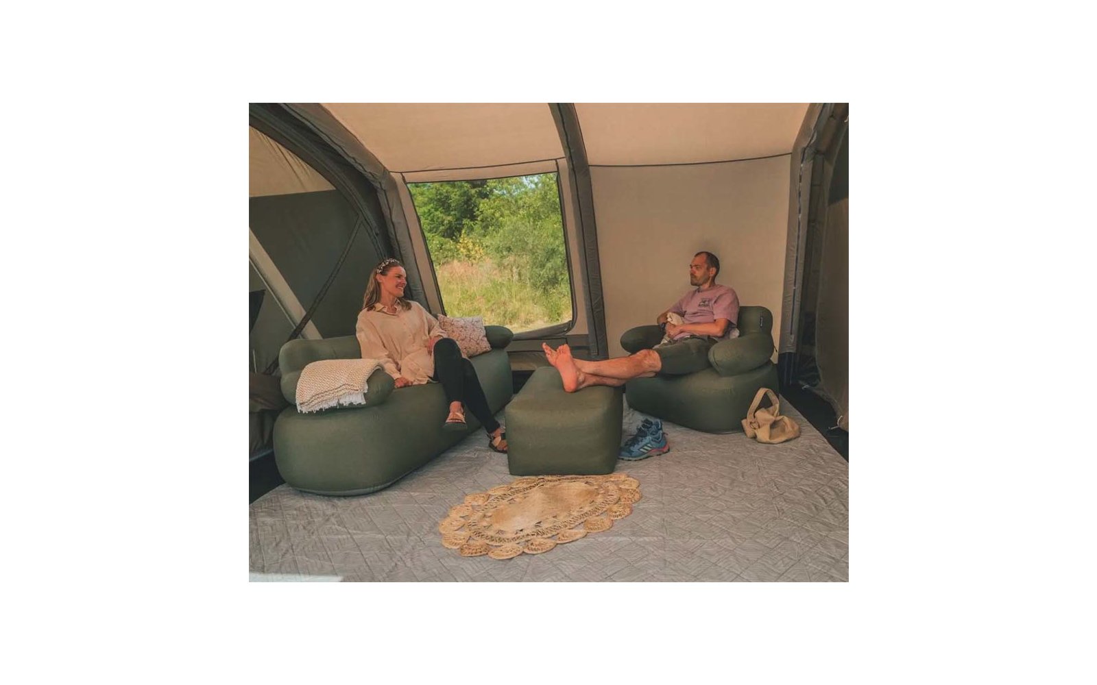 Zwei Personen sitzen auf Sitzsäcken in einem Raum mit großem Fenster