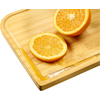 Two orange halves on a wooden cutting board with some juice on the board