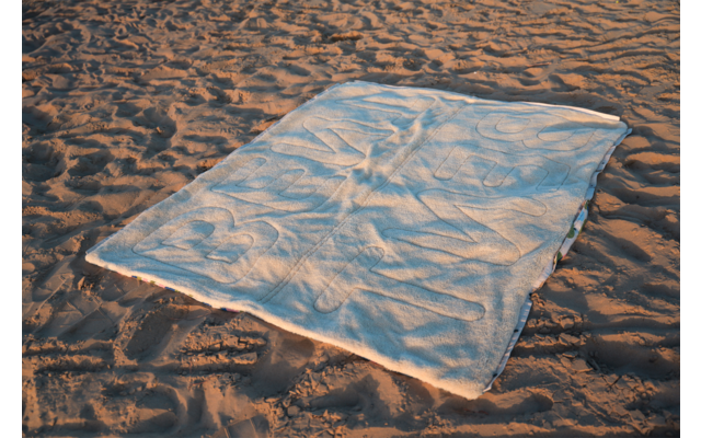 Tissu rectangulaire de couleur claire étalé sur du sable ondulé