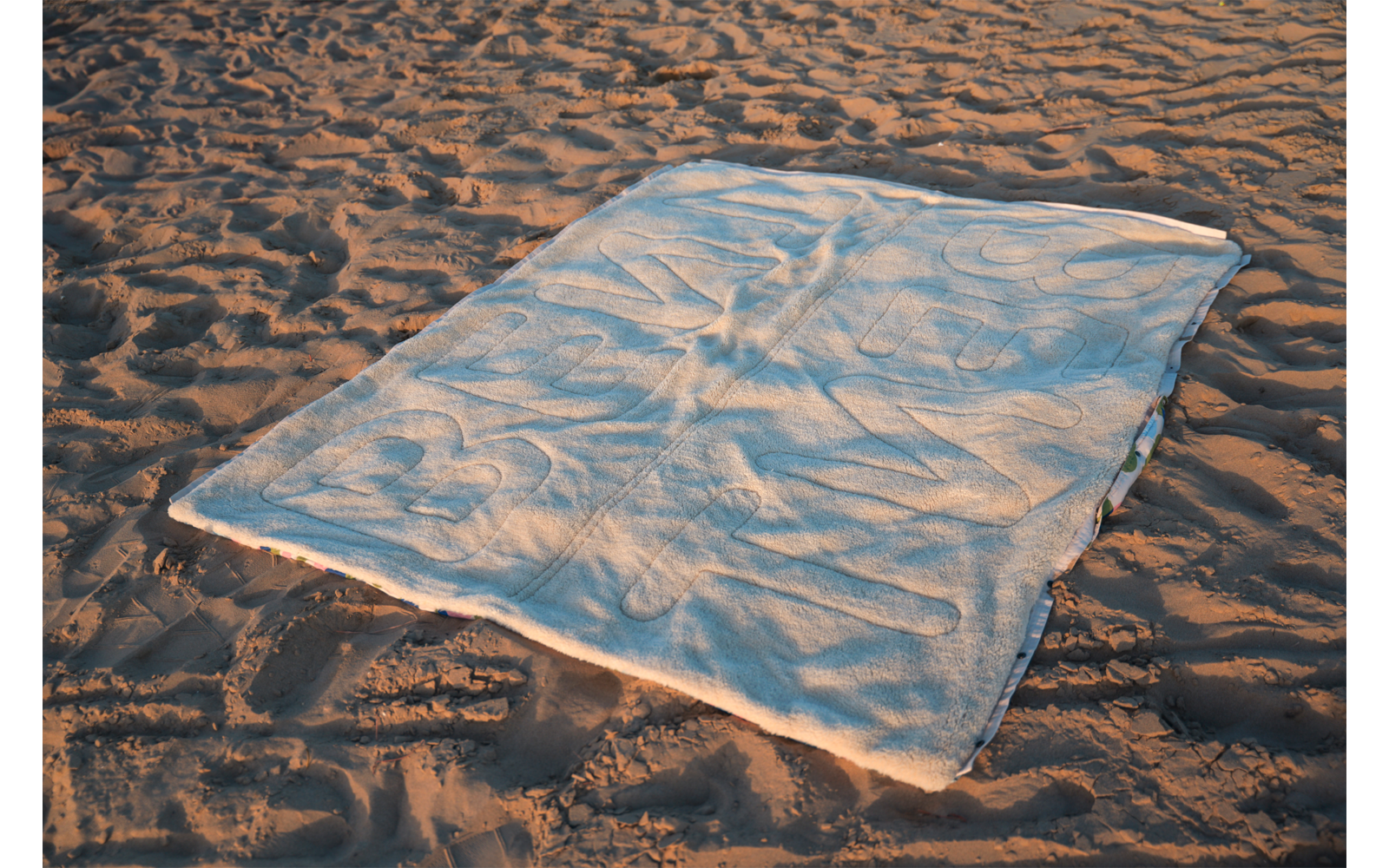 Tissu rectangulaire de couleur claire étalé sur du sable ondulé