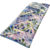 Matelas pneumatique rectangulaire à motif de feuilles colorées posé sur le sable; une serviette claire pliée au niveau de la tête; lumière du soleil et ombres sur le sable