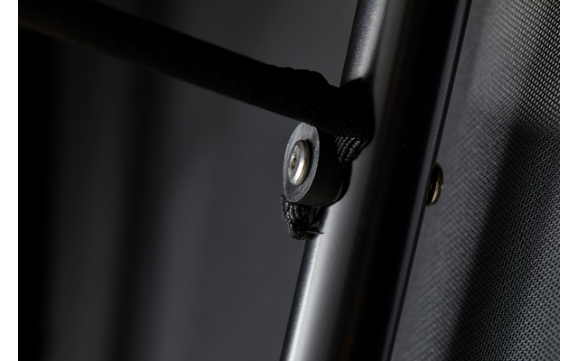 Nahaufnahme eines schwarzen Metallrohrs mit befestigtem schwarzem Gurt, Schraube und Unterlegscheibe, schwarzer Stoff im Hintergrund