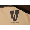 Schwarzes, stilisiertes "W" über dem Schriftzug "VICKYWOOD" auf beigem Stoff