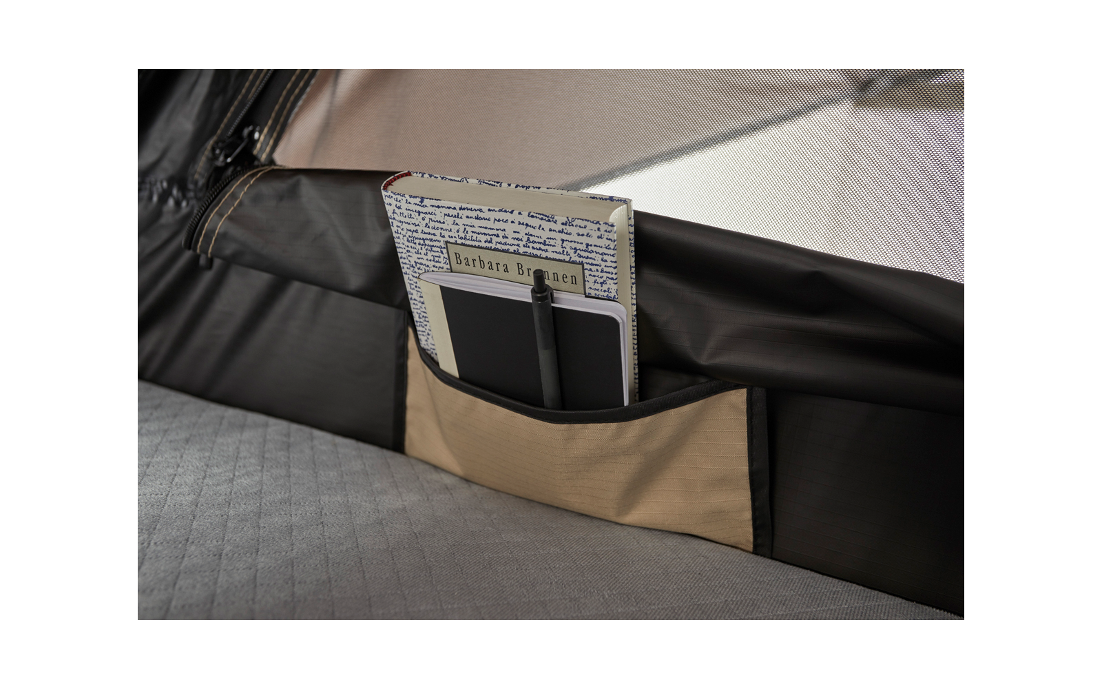 Beige Stofftasche mit Tablet, schwarzem Stift und Notizbuch mit bedrucktem Umschlag