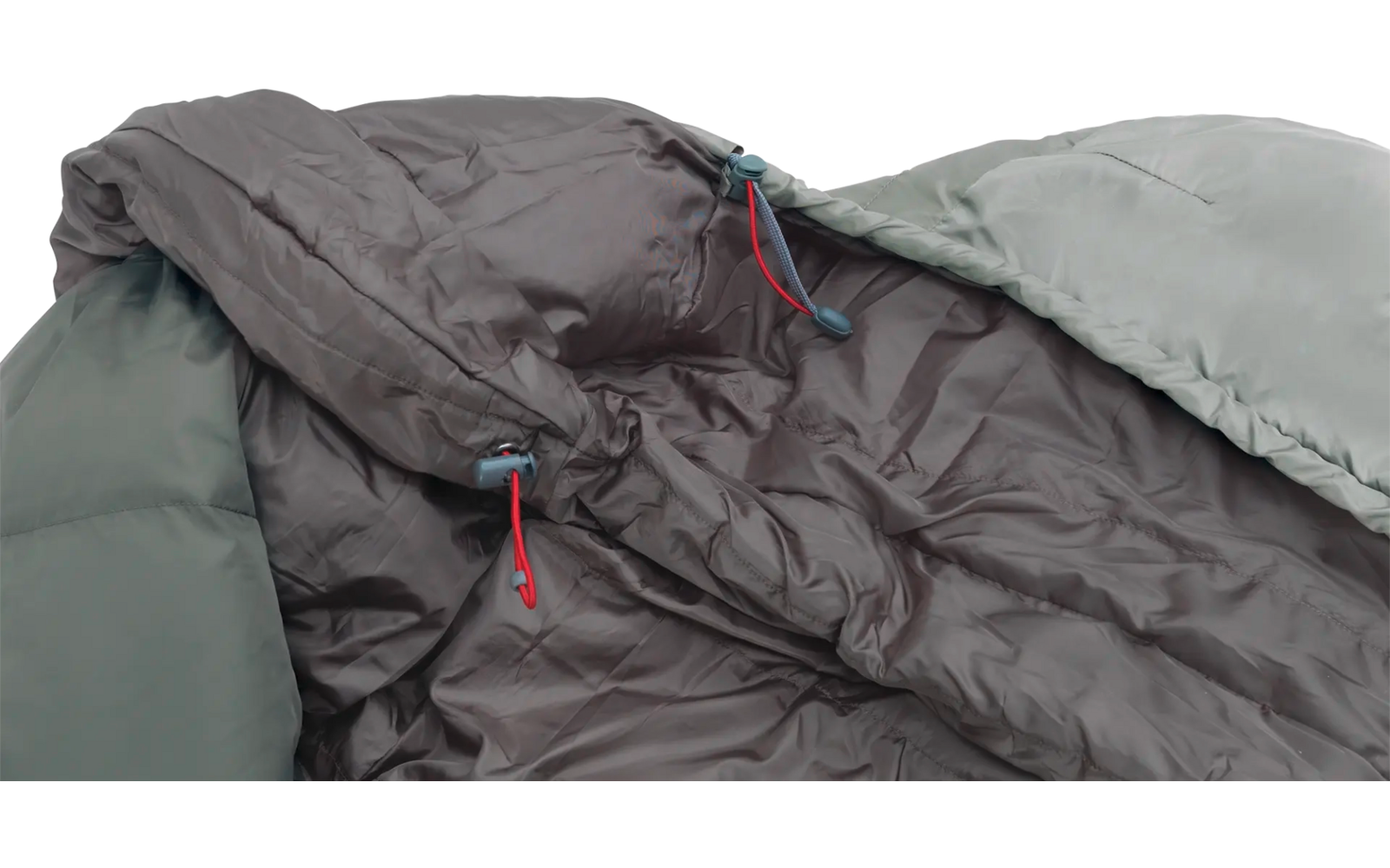 Ein dunkelgrauer Schlafsack mit einem blassgrünen Außenmaterial liegt ausgelegt