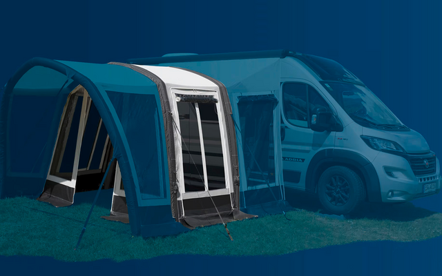 Toldo azul junto a una autocaravana blanca sobre césped verde