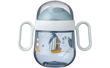 Tasse bleue et blanche avec deux poignées latérales et motif de voilier