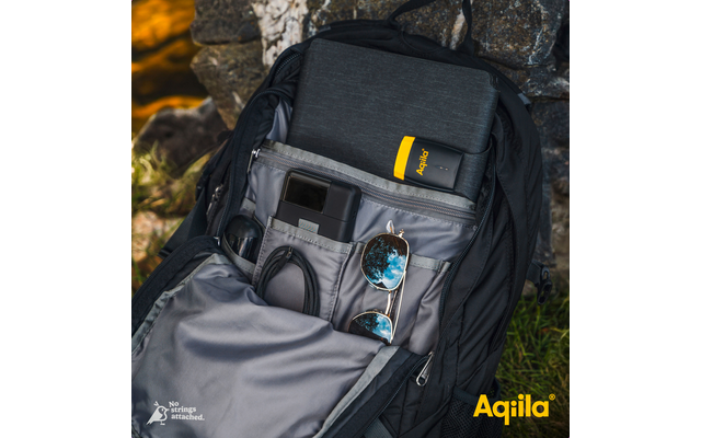 Ein offener schwarzer Rucksack mit mehreren Fächern, darin eine Kamera, eine Sonnenbrille und weiteres Zubehör