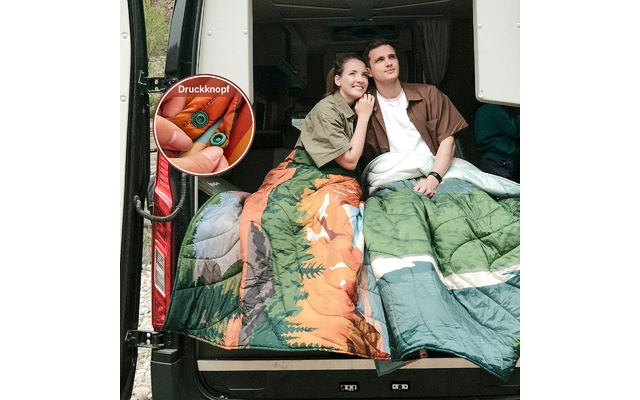 Zwei junge Personen sitzen zusammen in einem Lieferwagen, eingehüllt in bunte Decken, mit einem Basketball an der Seite