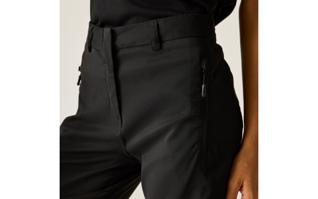 Detailaufnahme des Taillen- und Oberschenkelbereichs einer schwarzen Hose mit Reißverschlusstaschen, Bundschlaufen und einem teilweise sichtbaren Arm mit Hand