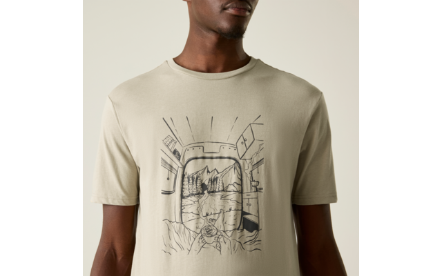 Oberkörper einer Person in beige T‑Shirt mit schwarzer Linienzeichnung: abgerundeter rechteckiger Rahmen, Berglandschaft mit See und Bäumen, felsiger Vordergrund und eine Hand, die eine Kamera hält