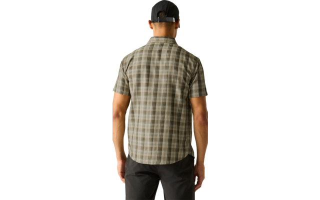 Person von hinten, trägt kariertes kurzärmeliges Hemd, schwarze Baseballkappe und dunkle Hose vor hellem einfarbigem Hintergrund