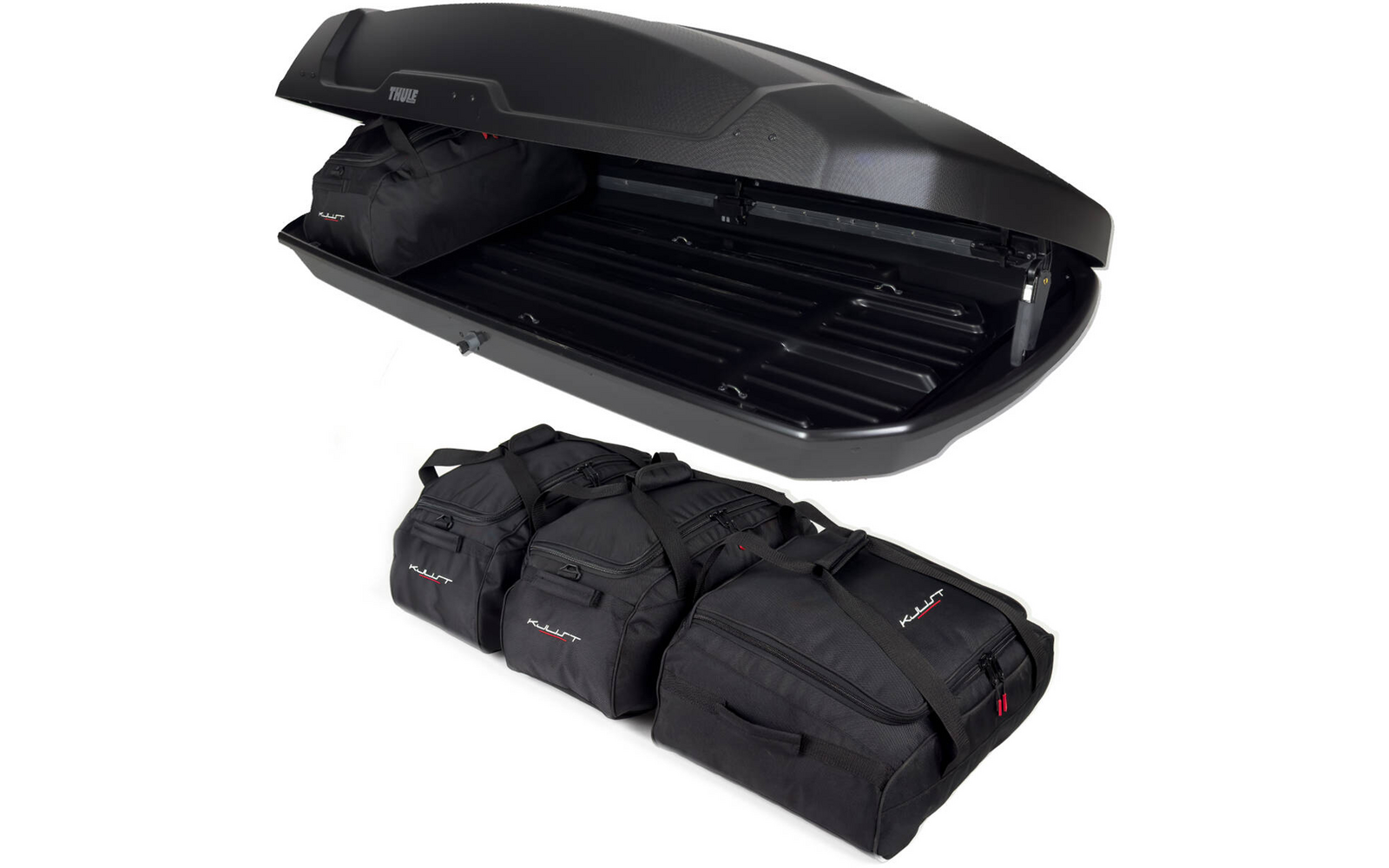 Geöffnete schwarze Dachbox, im Inneren drei schwarze Reisetaschen nebeneinander, davor drei weitere schwarze Reisetaschen auf weißem Hintergrund