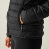 Person trägt eine schwarze gesteppte Jacke und hat eine Hand in der Hosentasche