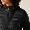 Person trägt eine schwarze Steppjacke und eine schwarze Umhängetasche